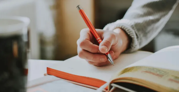 A person writing a novel with a clear time-bound goal to finish the first draft by a specific date, showcasing SMART goal setting