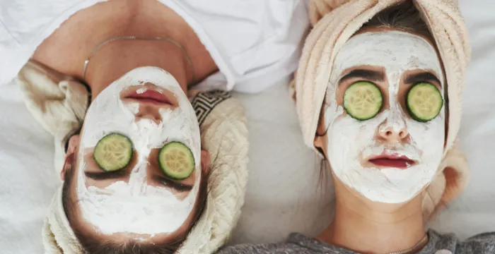 Two persons relaxing with a face mask and cucumber slices on their eyes, emphasizing self-care and stress management for emotional strength and creating resilience
