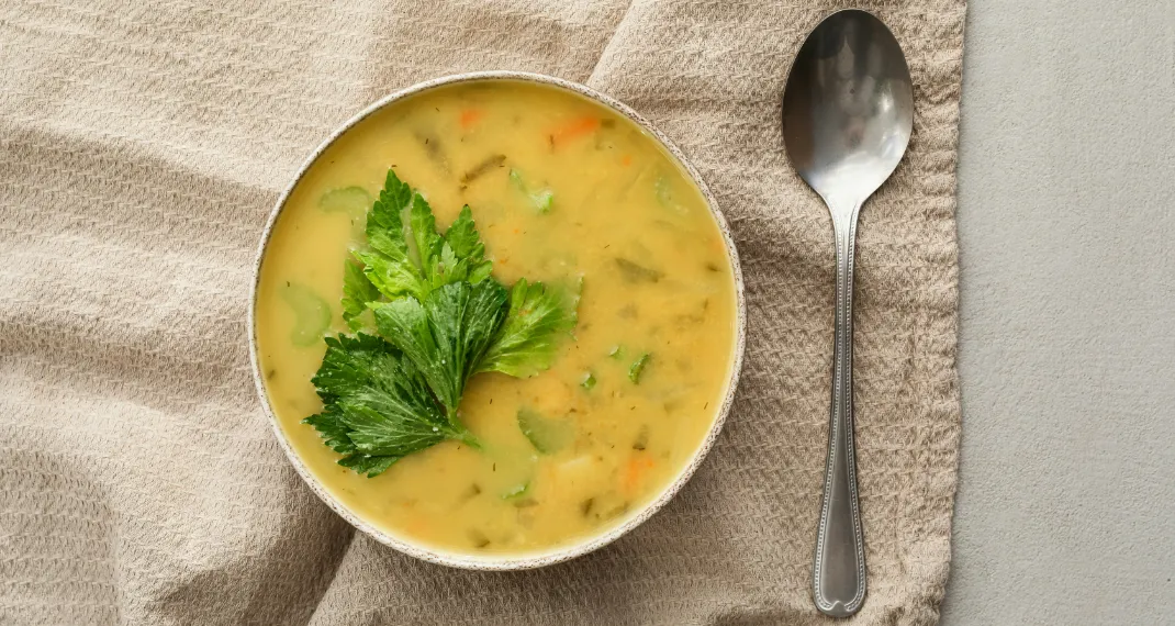 Bowl of hearty lentil and vegetable soup with a spoon, garnished with fresh parsley