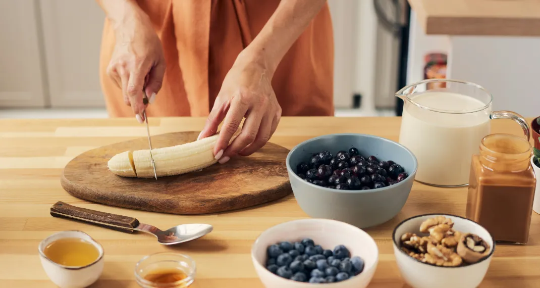 Banana peanut butter smoothie served in a glass with straw on wooden table